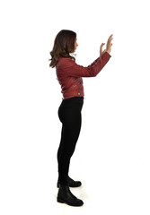 full length portrait of brunette lady wearing red fantasy costume with cloak, standing pose on grey studio background.