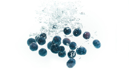 Blueberries falling into water.