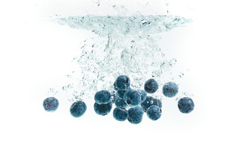 Blueberries falling into water.