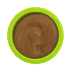 Top view of pears and blackberry organic baby food in a green bowl isolated on a white background.