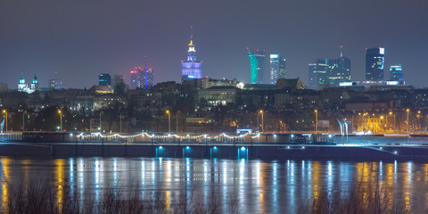 Fototapeta na wymiar festively lit modern skyscrapers and Old Town with reflection in the Vistula Riverat night, Warsaw, Poland.