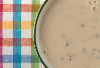 Creamy mushroom soup in a bowl atop a colorful place mat.