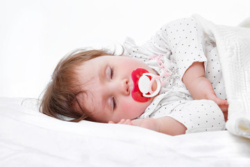 Portrait of a cute little girl sleeping on white pillow