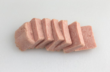 Several pressed pork canned meat chunks on a cutting board.