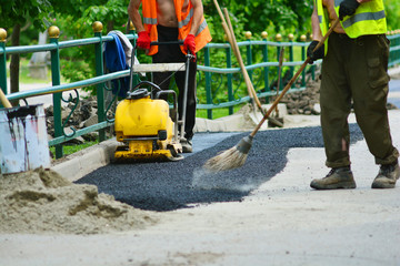 Road repair of asphalt of sidewalk in a park