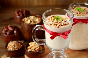 Milk protein cocktail with peanuts in a glass decorated with a red ribbon