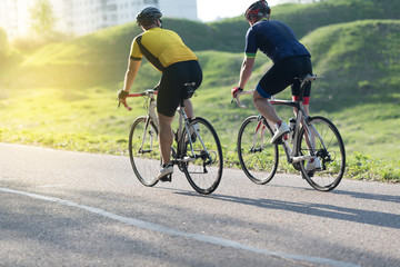 Active male athletes riding bicycles on an open country road