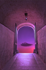 Purple cloud on pink sky with small star, through the gates of medieval fairy tale gates - concept for new dimensions, transition, dream, wishing or hope concept.
