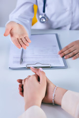 Female doctor giving a consultation to a patient and explaining medical informations and diagnosis. Just hands over the table. - 205672447