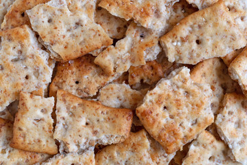 Close view of broken flatbread salted multigrain crackers.