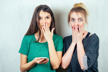 two beautiful and young girlfriends women gossip. the concept of eavesdropping and gossip