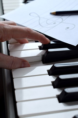 Black and white piano keys and musician's hands playing a tune