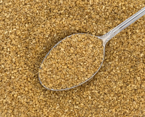 Close view of gold sugar on a spoon.