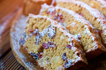 Fruitcake with dried fruits;  grapes, dried apricots, cranberry on wooden background.