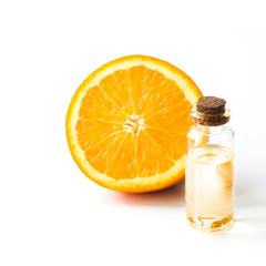 Orange slice fruit and bottle with oil or essence. Round slice isolated on white. Close up.