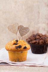 Homemade chocolate muffins with heart, vintage background.