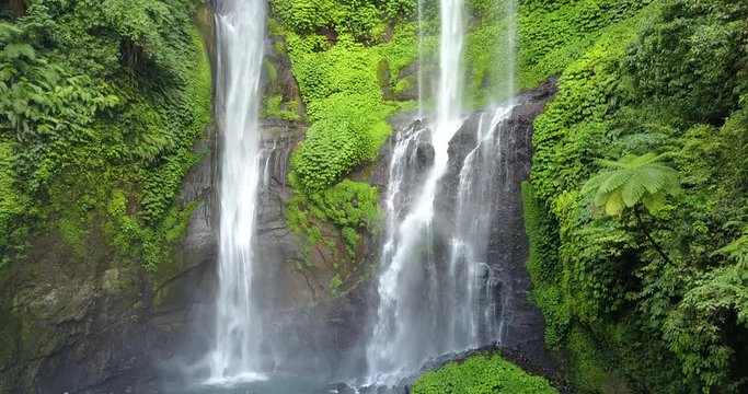 Sekumpul Waterfall in Bali with tourists, Indonesia . Drone aerial Shot