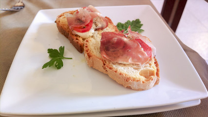 Fish snacks, Mediterranean cuisine on red tablecloth in Italian restaurant.