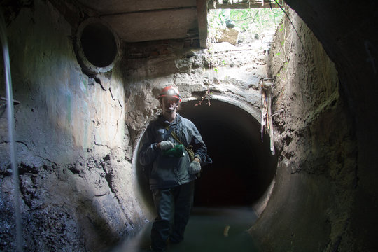 Sewer Worker In Underground Flooded Sewage Collector