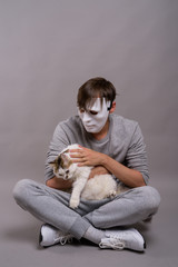Obraz premium Young handsome man wearing white mask against gray background
