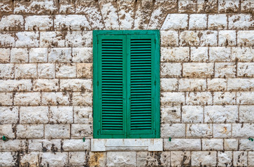 Fototapeta na wymiar Green shutters in a old brick facade