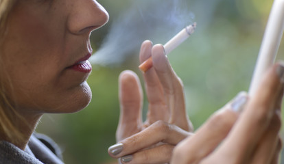 Plano Corto de Mujer Fumando Mientras Mira su Celular. 