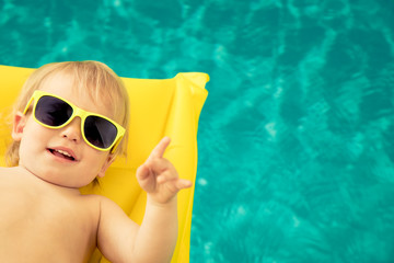 Funny baby boy in swimming pool