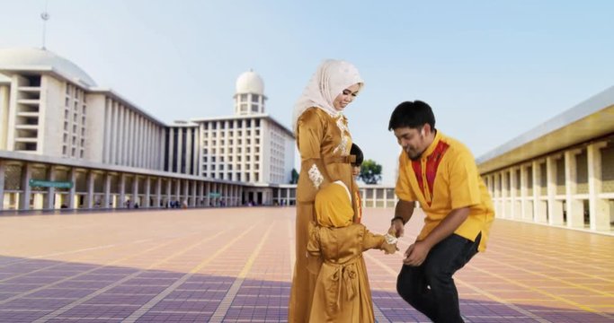 Two muslim children and their mother kissing father hand in the Istiqlal Mosque at Jakarta, Indonesia. Shot in 4k resolution