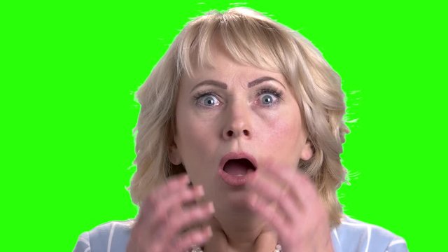 Close up face of mature scared woman. Portrait of anxious and shocked woman on chroma key background.