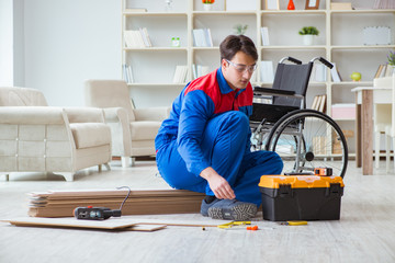 Disabled man laying floor laminate in office