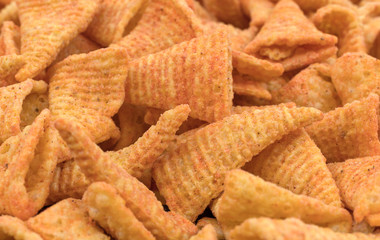 Close view of cheese flavored cone shaped corn chips.