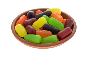 Chewy colorful candy in a small bowl isolated on a white background.