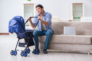 Young father looking after newborn baby at home