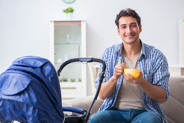 Young father looking after newborn baby at home