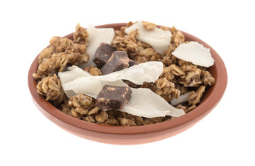 Organic granola with chocolate and coconut flakes in a small bowl isolated on a white background.