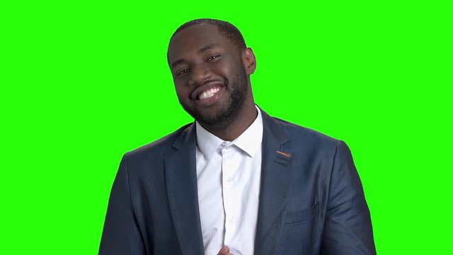 Flirtatious dark-skinned man on green screen. Attractive afro american is man flirting and inviting somebody with finger on chroma key background. Handsome smiling macho-man.