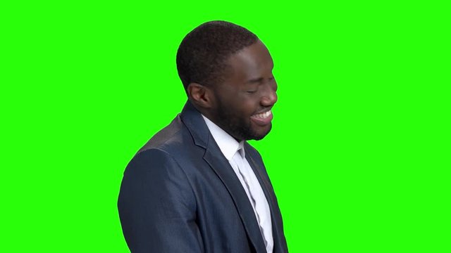 Young sexy stylish businessman on green screen. Smiling self-assertive dark-skinned businessman on Alpha Channel background.