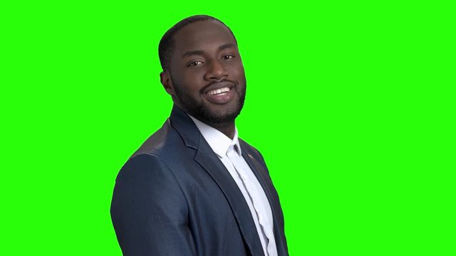 Young sexy dark-skinned businessman in suit. Portrait of attractive Afro-American businessman with air kiss on chroma key background. People, flirt, seduction.