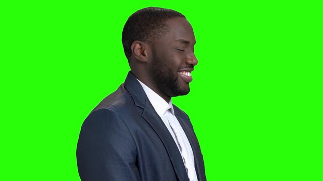Smiling businessman on chroma key background. Distrustful dark-skinned man in formal wear on Alpha Channel background.