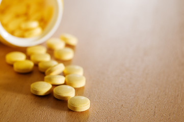Vitamin pills on wooden table.