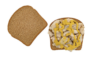 Chicken breast on wheat bread sandwich with mustard isolated on a white background.