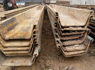Temporary sheet pile cofferdam retaining wall at the construction site. It is installed to allow soil excavation and foundation work start. 