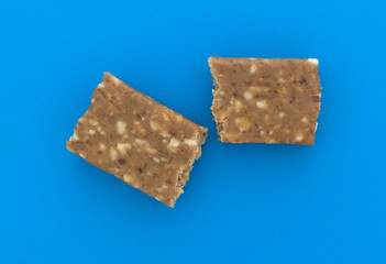 Cashew and date energy bar on a blue cutting board top view.