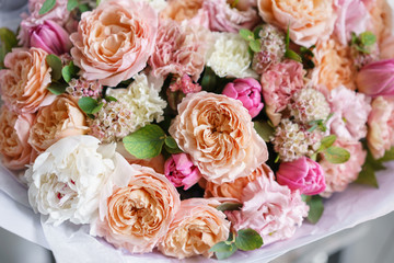 beautiful luxury bouquet of mixed flowers in woman hand. the work of the florist at a flower shop. Vertical photo