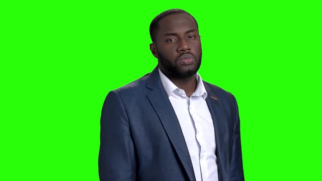 Stylish businessman adjusting his shirt. Confident handsome afro-american guy in business suit on chroma key background.