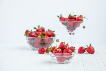 Fresh strawberries in a bowl on a white background.