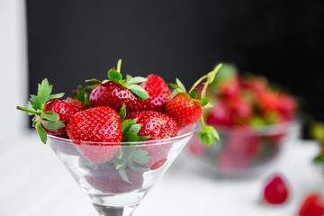 Fresh strawberries in a bowl on a white background.