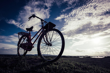 Fototapeta na wymiar Silhouette bicycle on the hill over sunset background.
