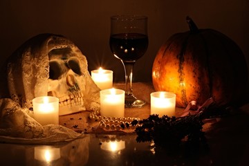 Human Skull with Veil, Burning Candles, Pearl Necklace, Glass of Wine and Pumpkins