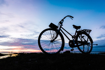 Fototapeta na wymiar Silhouette bicycle on the hill over sunset background.